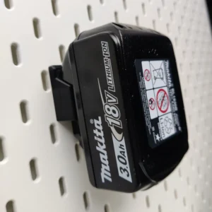 Makita 18v battery mounted on an ikea skadis pegboard with our mount